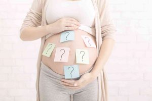 בחורה בהריון עם סימני שאלה על ביטנה