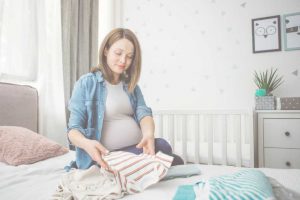 בחורה בהריון מקפלת כביסה