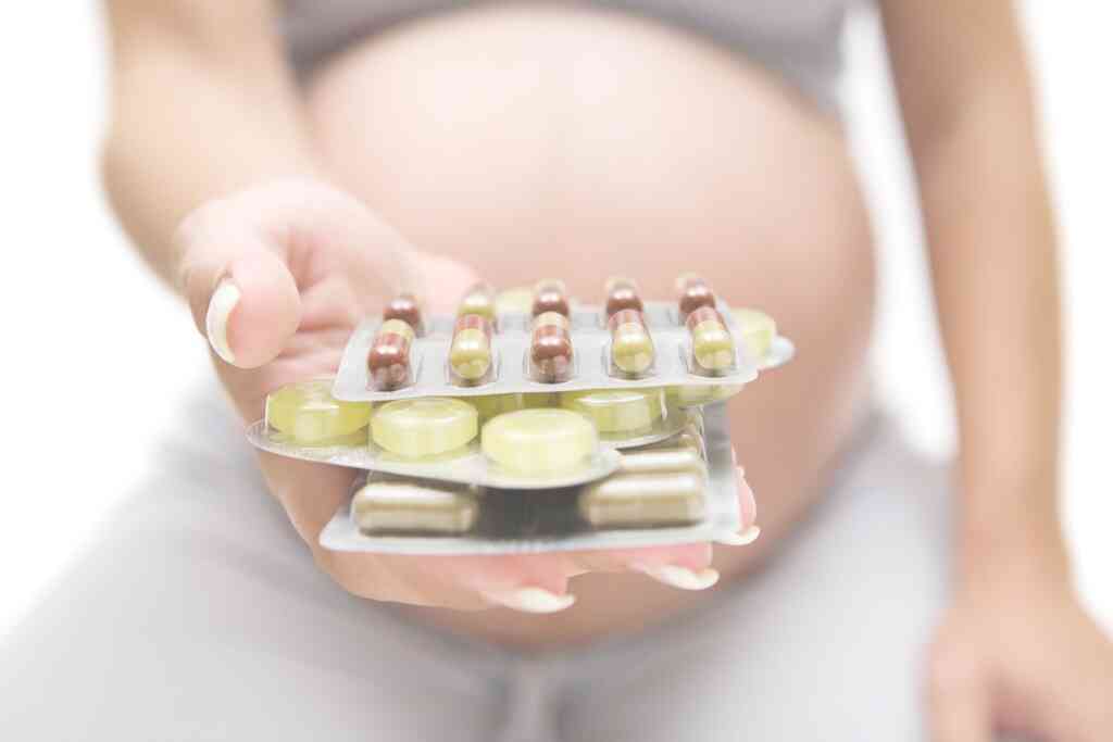בחורה בהריון מציגה תרופות