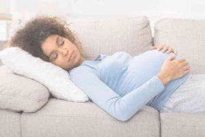 בחורה בהריון ישנה על ספה