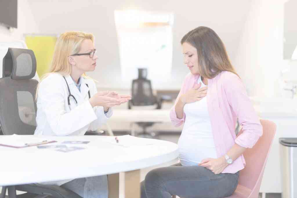 בחורה בהריון עם צרבת בביקור אצל הרופאה