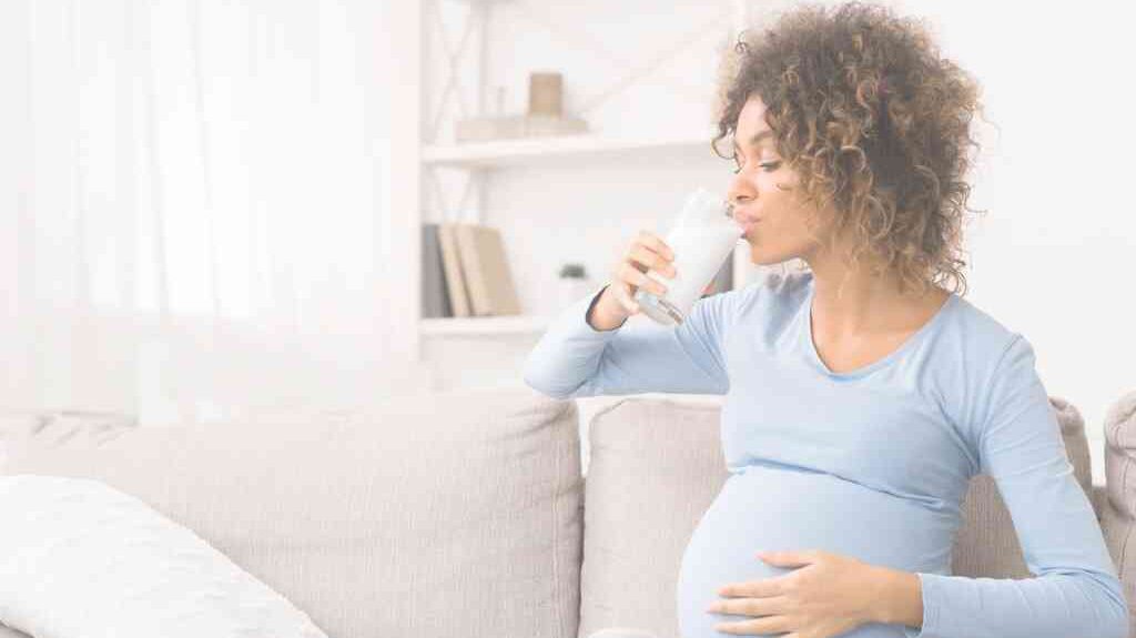 בחורה בהריון שותה כוס חלב נגד צרבת