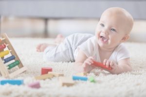תינוק משחק עם משחקי התפתחות על משטח פעילות
